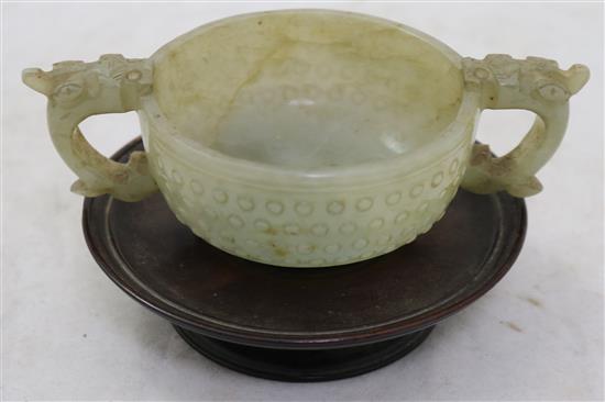 A Chinese celadon jade two handled cup, 17th century, width 12.5cm, rosewood stand